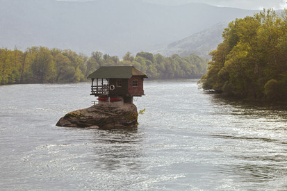 Symbolbild Hochwasser (Hütte auf Fels in Fluss)